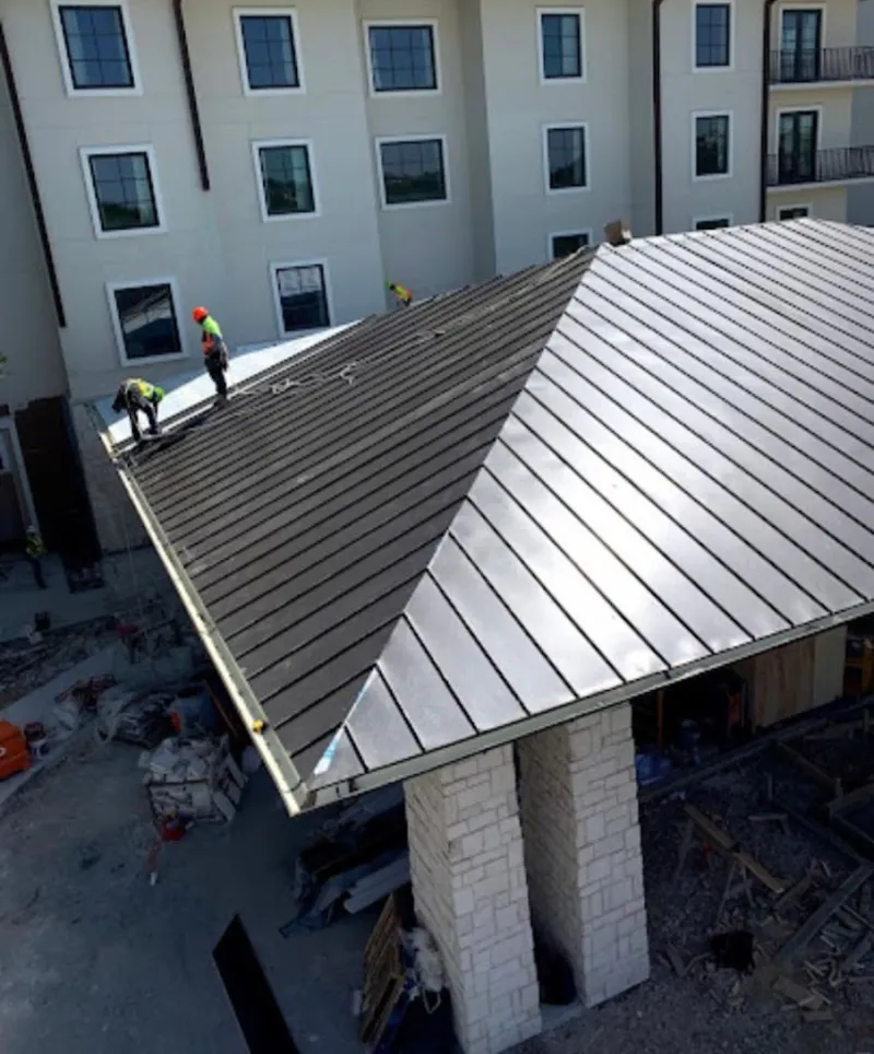 Crew installing standing seam metal roof panels on a commercial project in Hawaiian Paradise Park